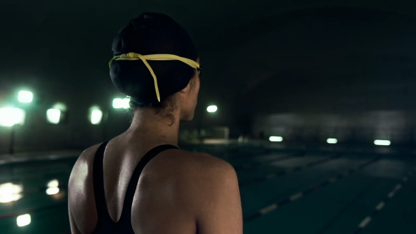 Nadadora observando una piscina nocturna